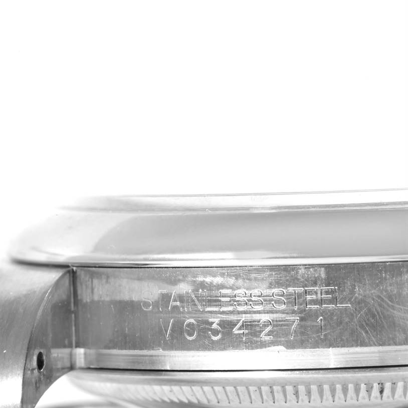 This image shows a close-up side view of the case back for a Rolex Oyster Perpetual 116000 Men
s Stainless Steel Black Dial 116000 Men
s Stainless Steel Black Dial watch, highlighting the stainless steel material and serial number.