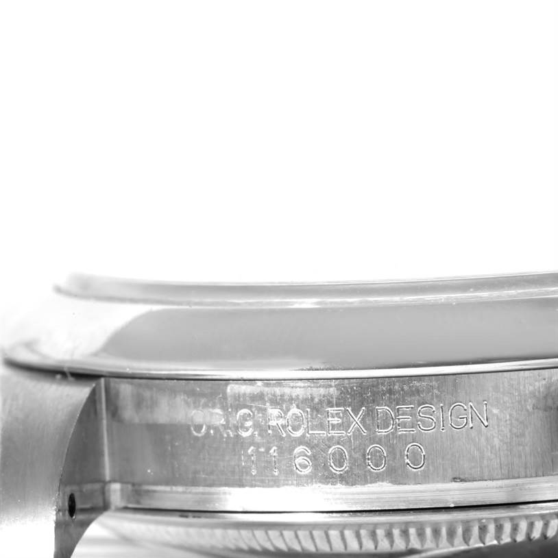 This close-up image shows the side case and part of the bezel of a Rolex Oyster Perpetual 116000 Men
s Stainless Steel Black Dial 116000 Men
s Stainless Steel Black Dial, highlighting the "ORIG ROLEX DESIGN" engraving.