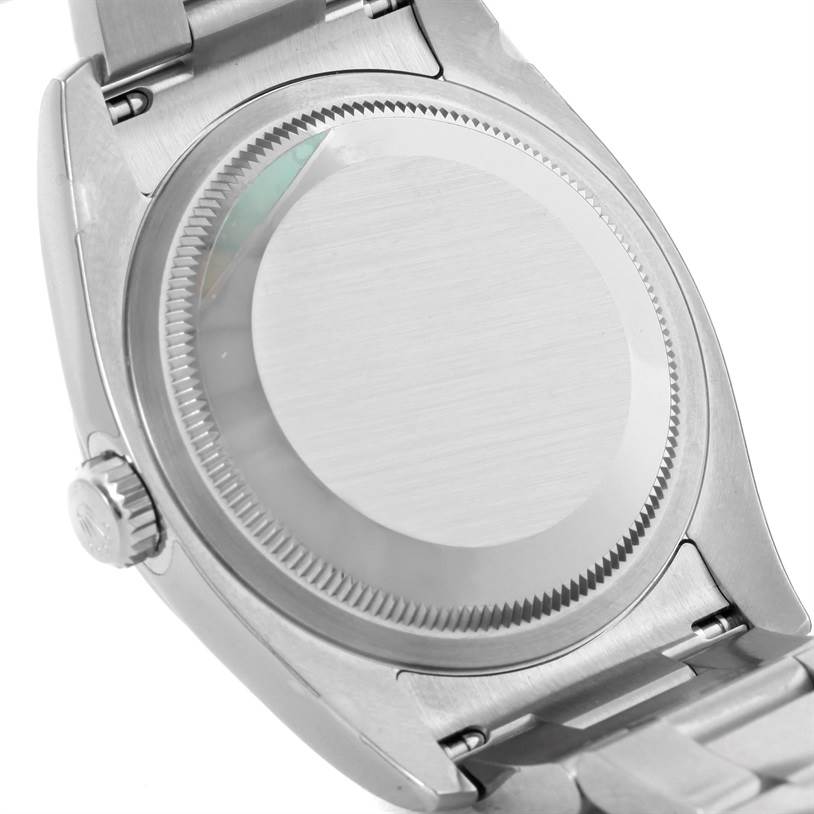 The image shows the back case and part of the bracelet of a Rolex Oyster Perpetual 116000 Men's Stainless Steel Silver Dial 116000 Men's Stainless Steel Silver Dial watch.