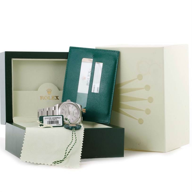 The image shows a Rolex Oyster Perpetual 116000 Men's Stainless Steel Silver Dial 116000 Men's Stainless Steel Silver Dial watch with its box, warranty card, and cleaning cloth.