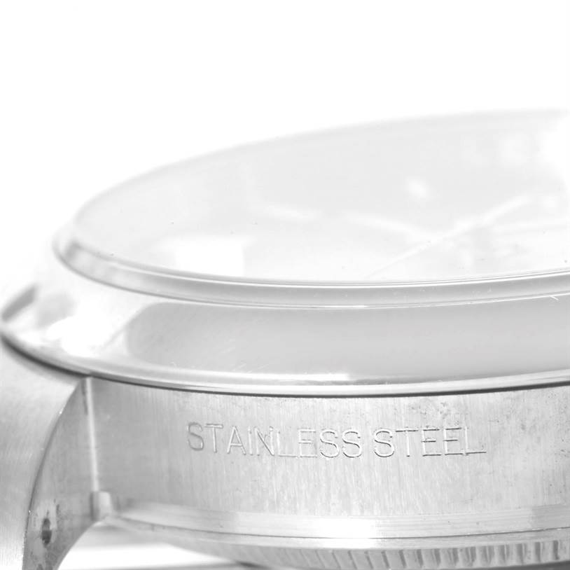 This close-up angle of the Rolex Oyster Perpetual 116000 Stainless Steel Silver Dial 116000 Stainless Steel Silver Dial model shows the side of the watch case with "STAINLESS STEEL" engraved on it.