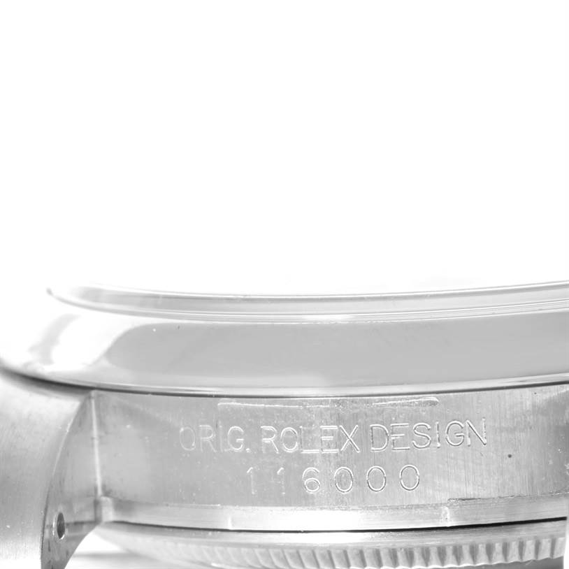 The image shows a close-up of the side of the Rolex Oyster Perpetual 116000 Men's Stainless Steel Black Dial 116000 Men's Stainless Steel Black Dial watch case, highlighting the model number and design engravings.