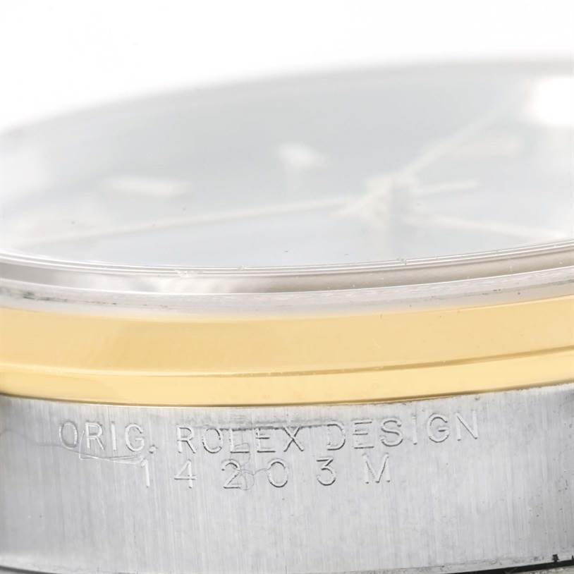 The image shows a close-up of the side of a Rolex Oyster Perpetual 14203 Men's Steel and Gold (two tone) Grey Dial 14203 Men's Steel and Gold (two tone) Grey Dial watch, highlighting the bezel and the engraved model information.