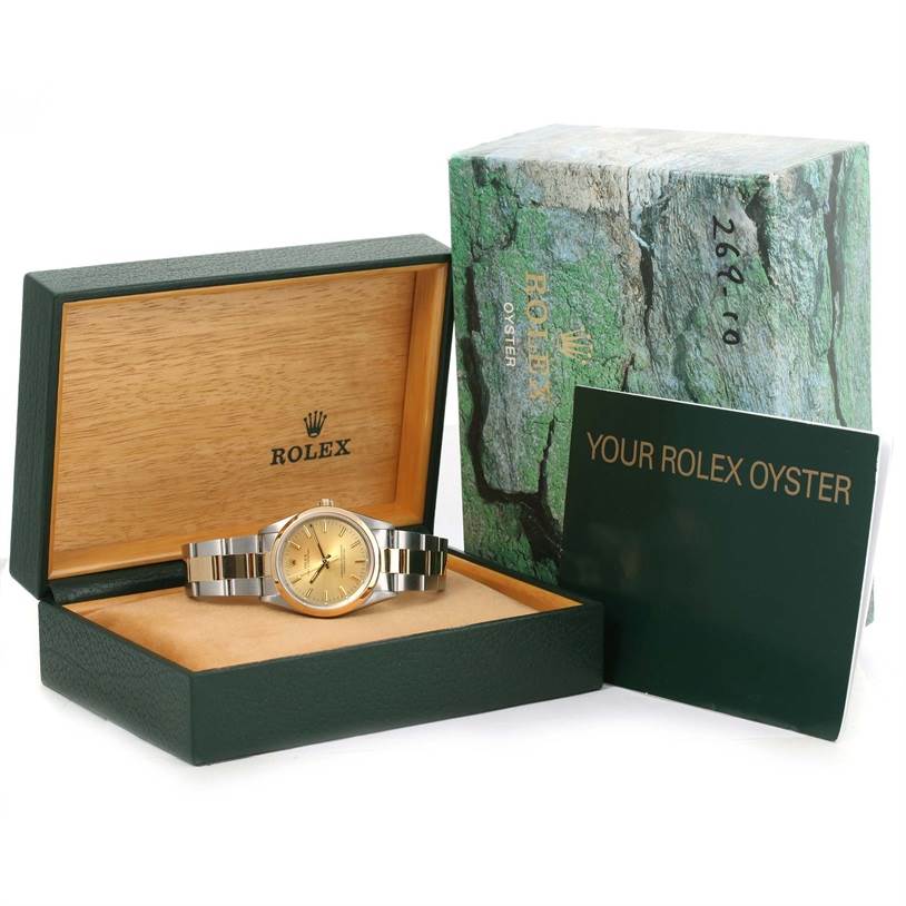 The image shows a Rolex Oyster Perpetual 14203 Men
s Steel and Gold (two tone) Champagne Dial 14203 Men
s Steel and Gold (two tone) Champagne Dial watch, its box, outer case, and accompanying booklet.