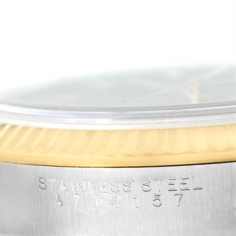 This close-up angle of the Rolex Oyster Perpetual 14233 Men's Steel and Gold (two tone) Grey Dial 14233 Men's Steel and Gold (two tone) Grey Dial watch shows the stainless steel casing and part of the fluted bezel.