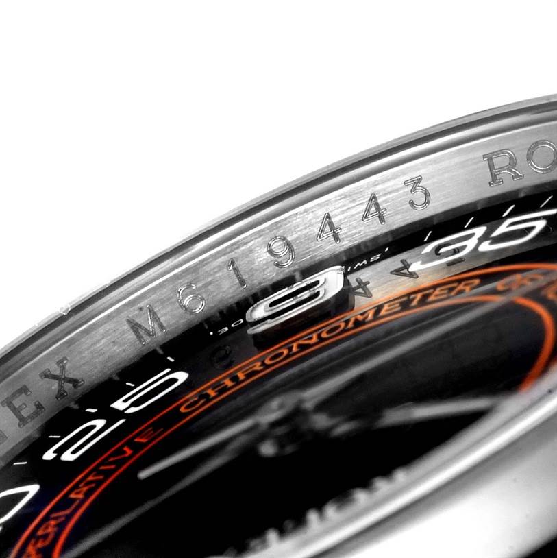 This close-up image shows the bezel and part of the dial of a Rolex Oyster Perpetual 116000 Men's Stainless Steel Black Dial 116000 Men's Stainless Steel Black Dial watch, including the serial number.