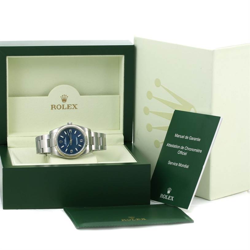 The image shows a Rolex Oyster Perpetual 116034 Men
s Stainless Steel Blue Dial 116034 Men
s Stainless Steel Blue Dial watch in its box with its manual and warranty card.