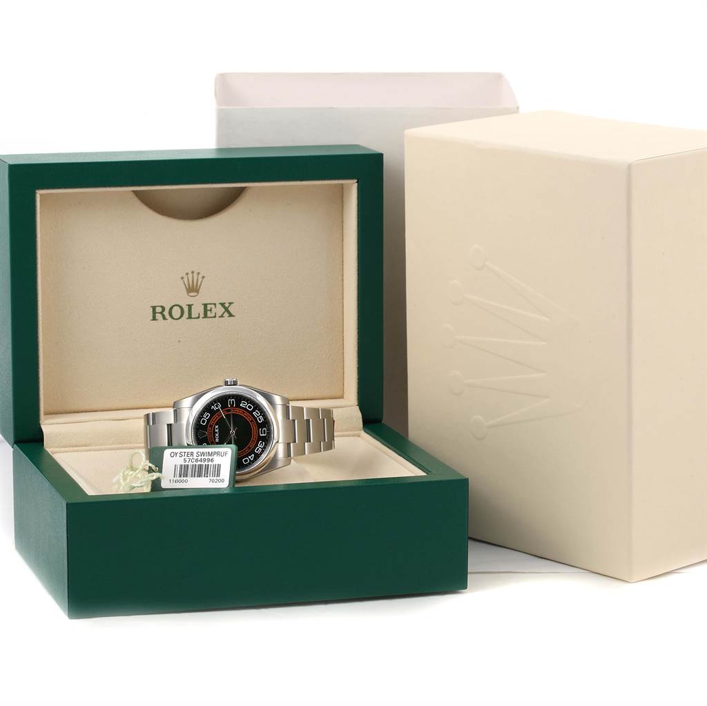 The image shows a Rolex Oyster Perpetual 116000 Men's Stainless Steel Black Dial 116000 Men's Stainless Steel Black Dial watch in its green and beige box, with the watch face and bracelet visible.