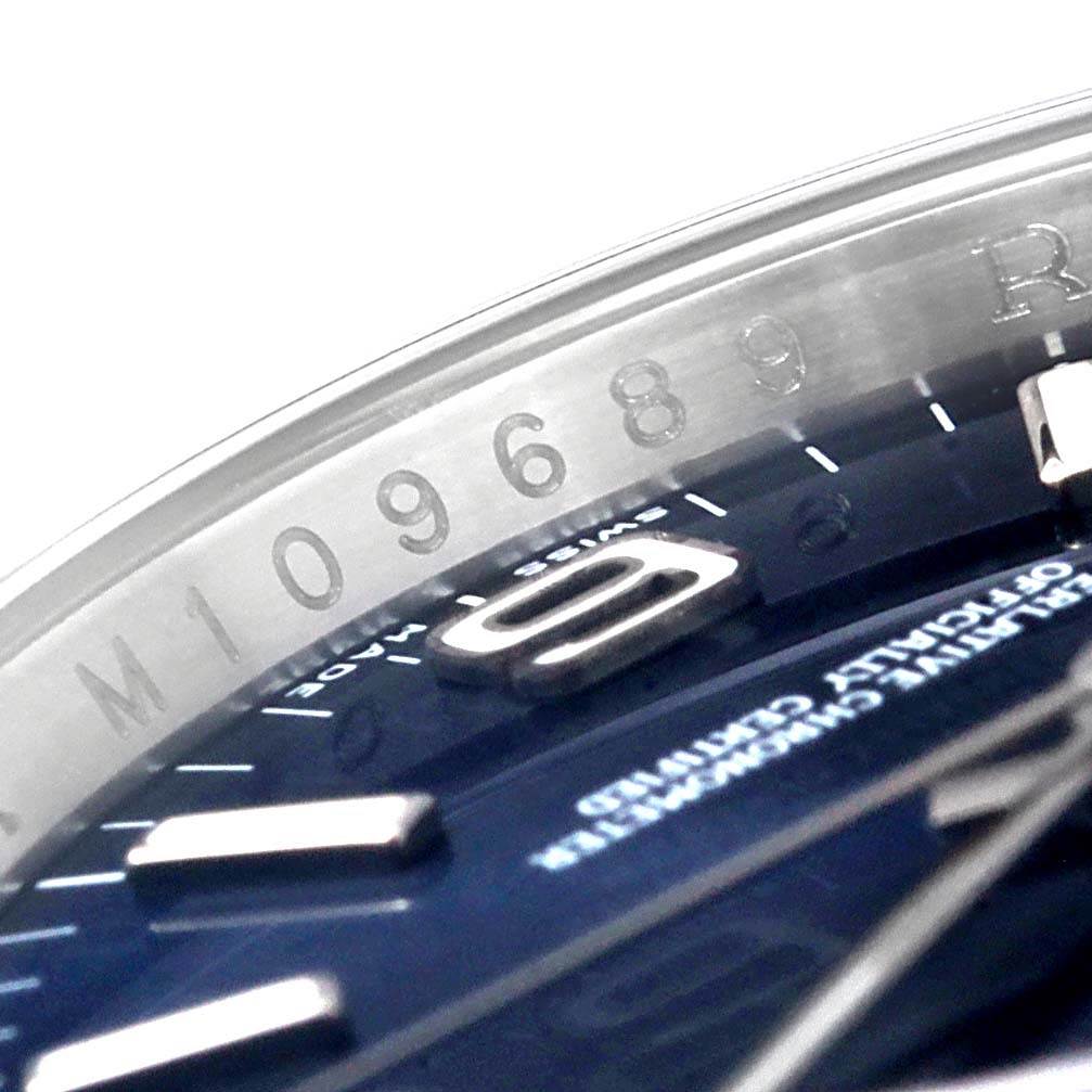 This image shows a close-up of the dial, bezel, and part of the model number of the Rolex Oyster Perpetual 116000 Men's Blue Dial 116000 Men's Blue Dial watch.