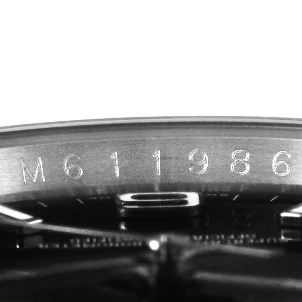 This image shows a close-up of the serial number engraved on the inner bezel of a Rolex Oyster Perpetual 116000 Men's Stainless Steel Black Dial 116000 Men's Stainless Steel Black Dial watch.