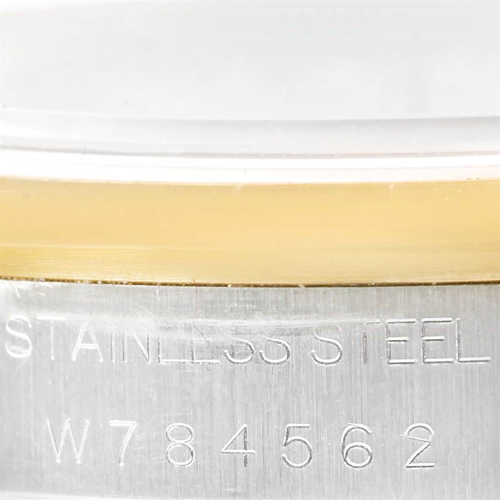 This close-up image features the side of a Rolex Oyster Perpetual 14203 Men
s Steel and Gold (two tone) White Dial 14203 Men
s Steel and Gold (two tone) White Dial watch case, highlighting the "Stainless Steel" engraving and serial number.