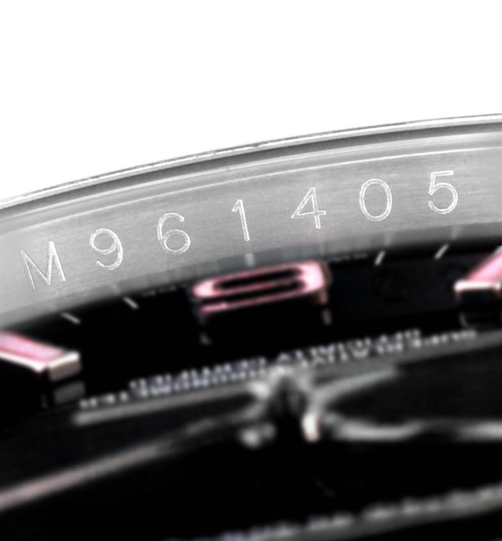 This image shows a close-up of the serial number engraving on the case of a Rolex Oyster Perpetual 116000 Men's Stainless Steel Black Dial 116000 Men's Stainless Steel Black Dial watch.