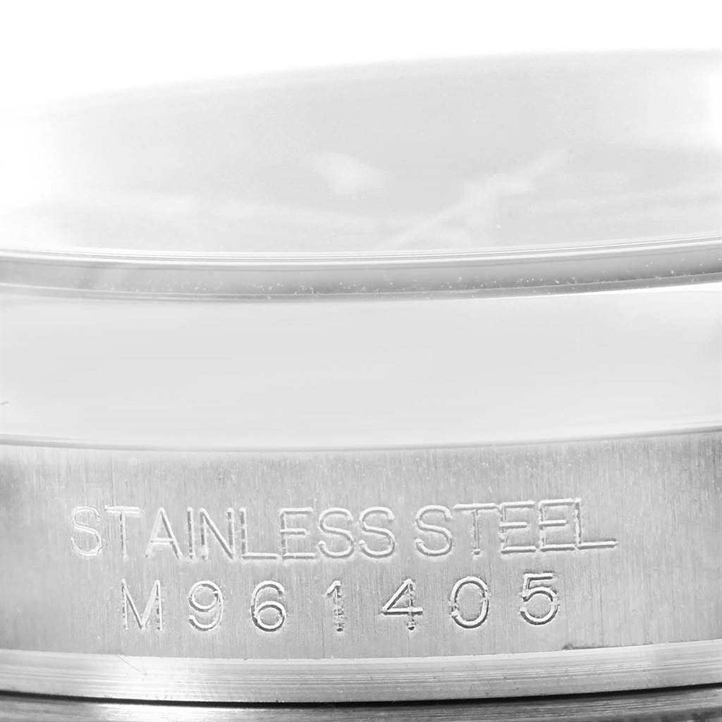 This image shows a close-up of the case side of a Rolex Oyster Perpetual 116000 Men's Stainless Steel Black Dial 116000 Men's Stainless Steel Black Dial watch, highlighting the stainless steel and serial number engraving.