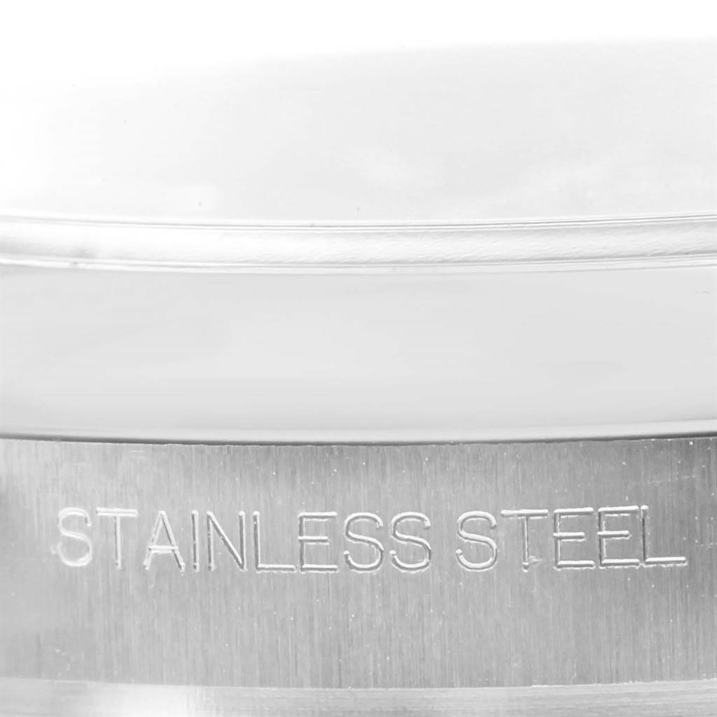 This is a close-up shot of the side of the stainless steel casing on a Rolex Oyster Perpetual 116000 Men's Stainless Steel Black Dial 116000 Men's Stainless Steel Black Dial watch.