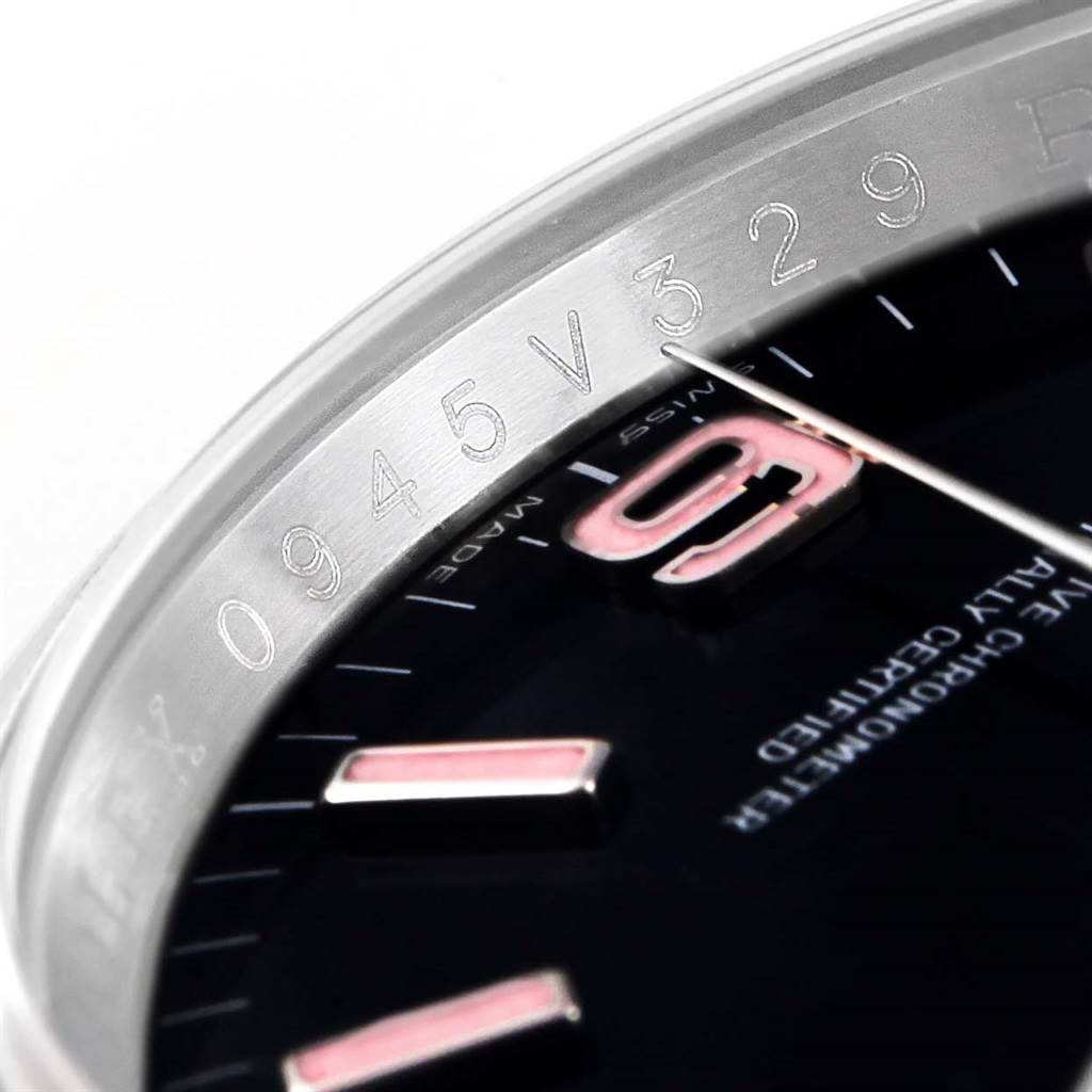 The close-up angle of the Rolex Oyster Perpetual 116000 Men's Stainless Steel Black Dial 116000 Men's Stainless Steel Black Dial watch shows part of the bezel, a few hour markers, and some serial markings.
