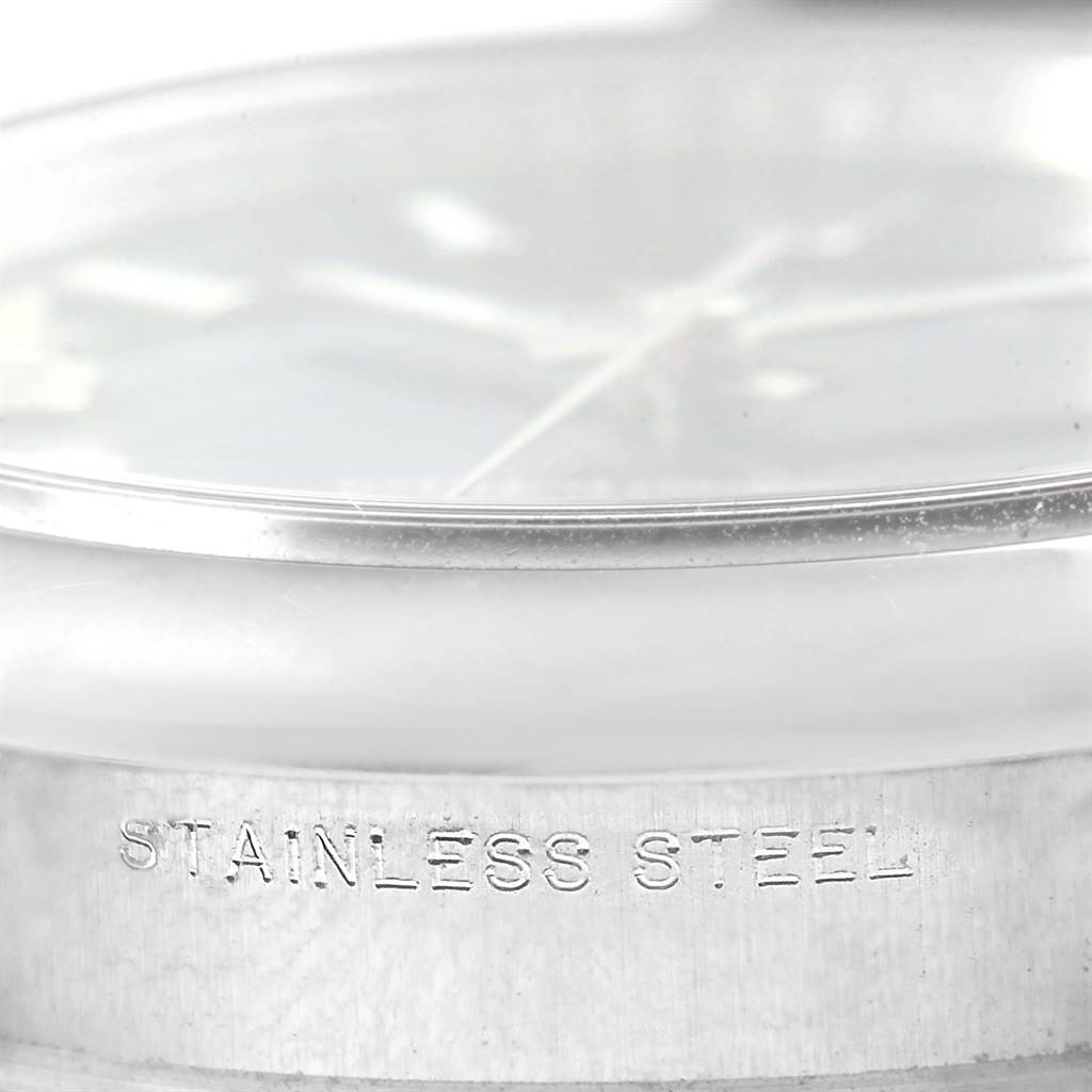 This image shows a close-up of the case and partially visible dial of a Rolex Oyster Perpetual 114200 Men's Stainless Steel Blue Dial 114200 Men's Stainless Steel Blue Dial watch, emphasizing its stainless steel construction.