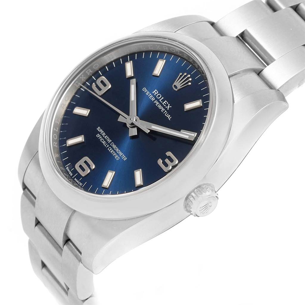 The image shows a side angle of a Rolex Oyster Perpetual 114200 Men's Stainless Steel Blue Dial 114200 Men's Stainless Steel Blue Dial watch, highlighting its blue dial and stainless steel bracelet.