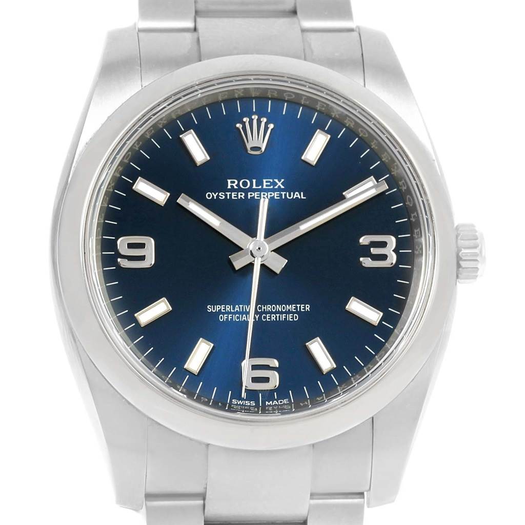 The image shows a front view of the Rolex Oyster Perpetual 114200 Men's Stainless Steel Blue Dial 114200 Men's Stainless Steel Blue Dial watch, highlighting the dial, bezel, and part of the bracelet.