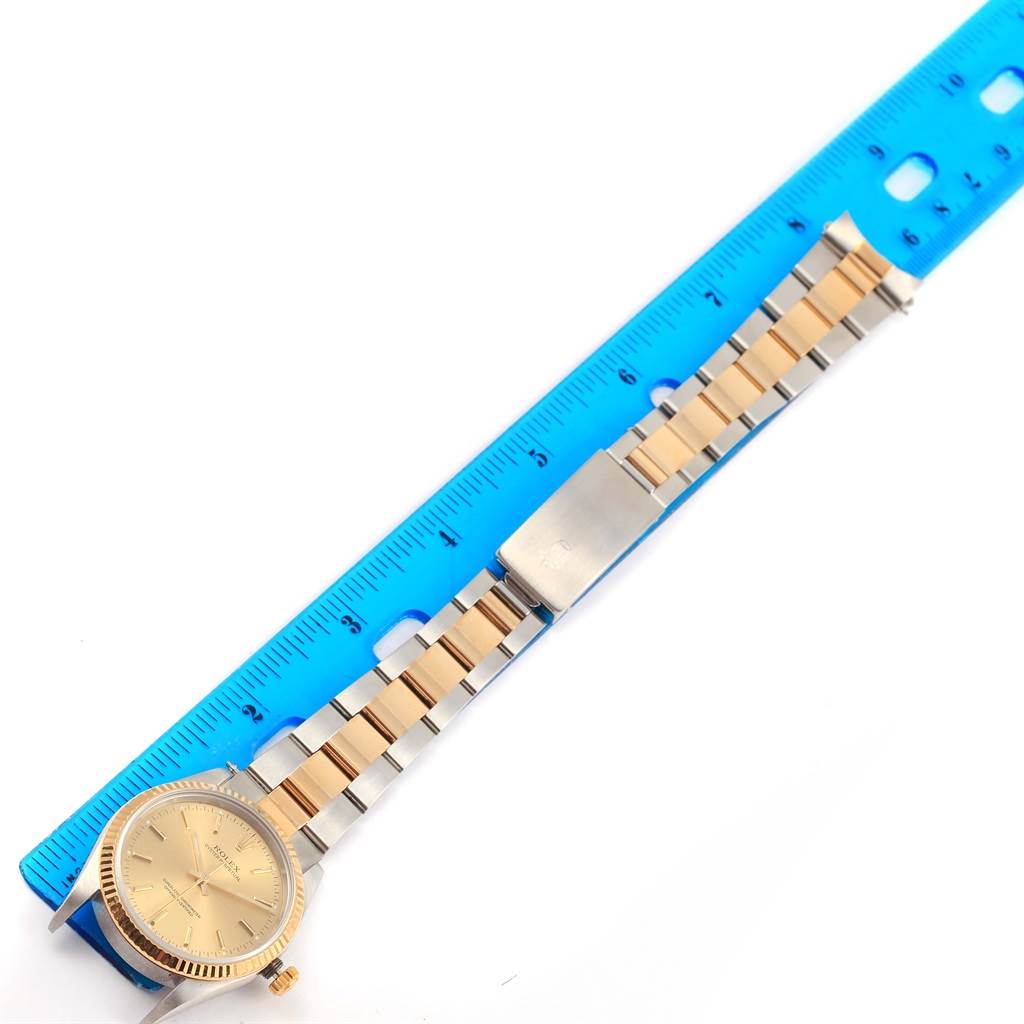 The image shows a top-down view of a Rolex Oyster Perpetual 14233 Men's Steel and Gold (two tone) Champagne Dial 14233 Men's Steel and Gold (two tone) Champagne Dial watch, displaying its face, bezel, bracelet, and clasp alongside a ruler.