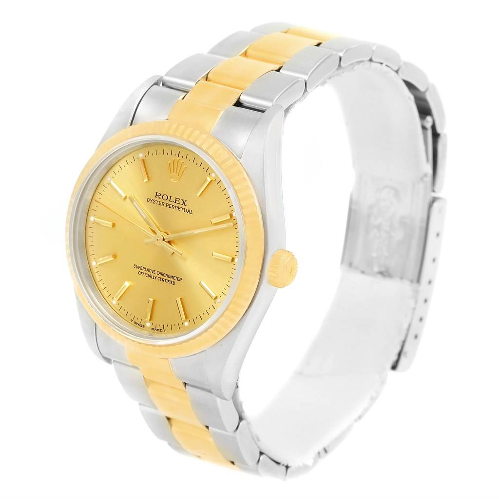 The image shows an angled view of a Rolex Oyster Perpetual 14233 Men's Steel and Gold (two tone) Champagne Dial 14233 Men's Steel and Gold (two tone) Champagne Dial watch, highlighting its gold dial, bezel, and a two-tone bracelet.