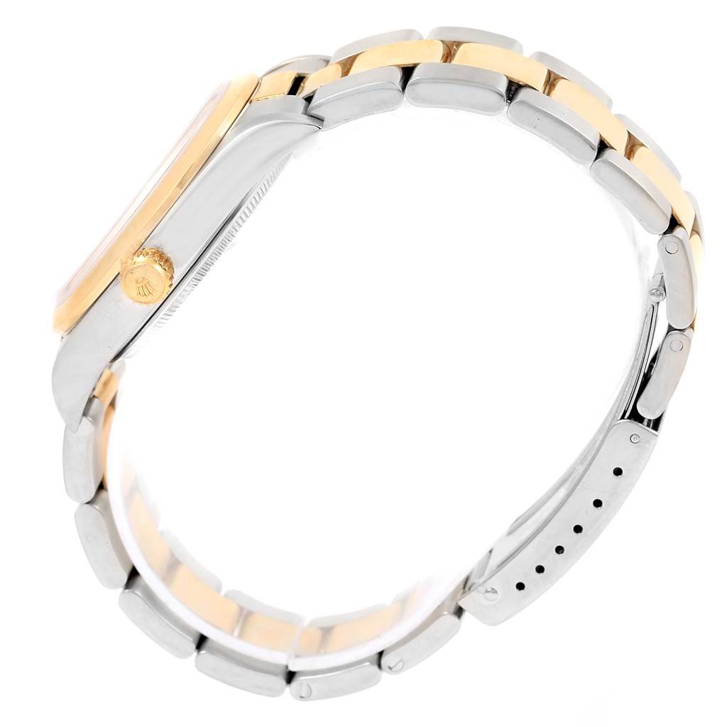 This side angle view of the Rolex Oyster Perpetual 14203 Men's Steel and Gold (two tone) Silver Dial 14203 Men's Steel and Gold (two tone) Silver Dial shows the watch's crown and two-tone bracelet.