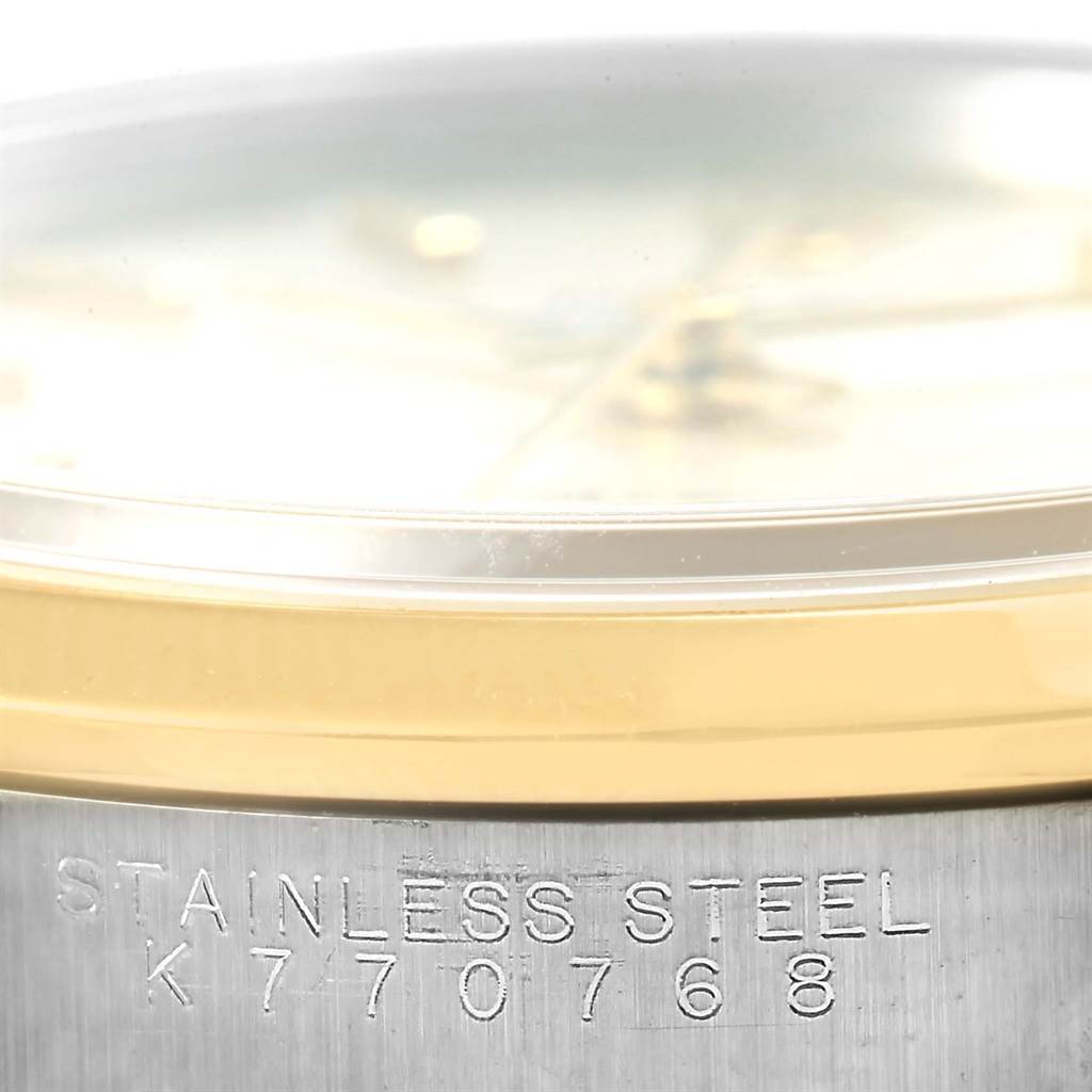 The image shows a close-up side view of a Rolex Oyster Perpetual 14203 Men's Steel and Gold (two tone) Silver Dial 14203 Men's Steel and Gold (two tone) Silver Dial watch, highlighting the stainless steel case and bezel with serial number engraving.