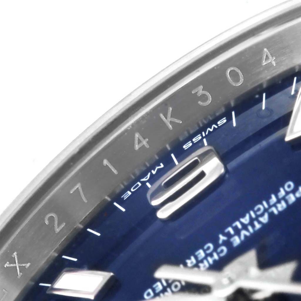 This image shows a close-up angle of the bezel, part of the blue dial, and a numeric marking of the Rolex Oyster Perpetual 114200 Stainless Steel Blue Dial 114200 Stainless Steel Blue Dial watch.