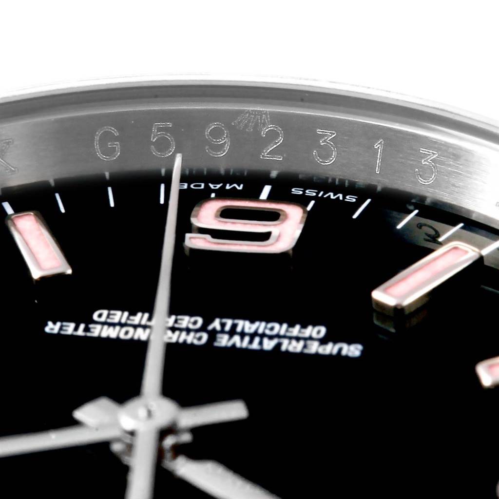 This close-up angle of the Rolex Oyster Perpetual 116000 Men's Stainless Steel Black Dial 116000 Men's Stainless Steel Black Dial watch shows the dial, hands, and part of the serial number and branding.