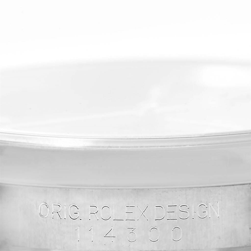 The image shows the side view of the caseback of a Rolex Oyster Perpetual 114300 Men's Stainless Steel Blue Dial 114300 Men's Stainless Steel Blue Dial watch, displaying the model number 114300.