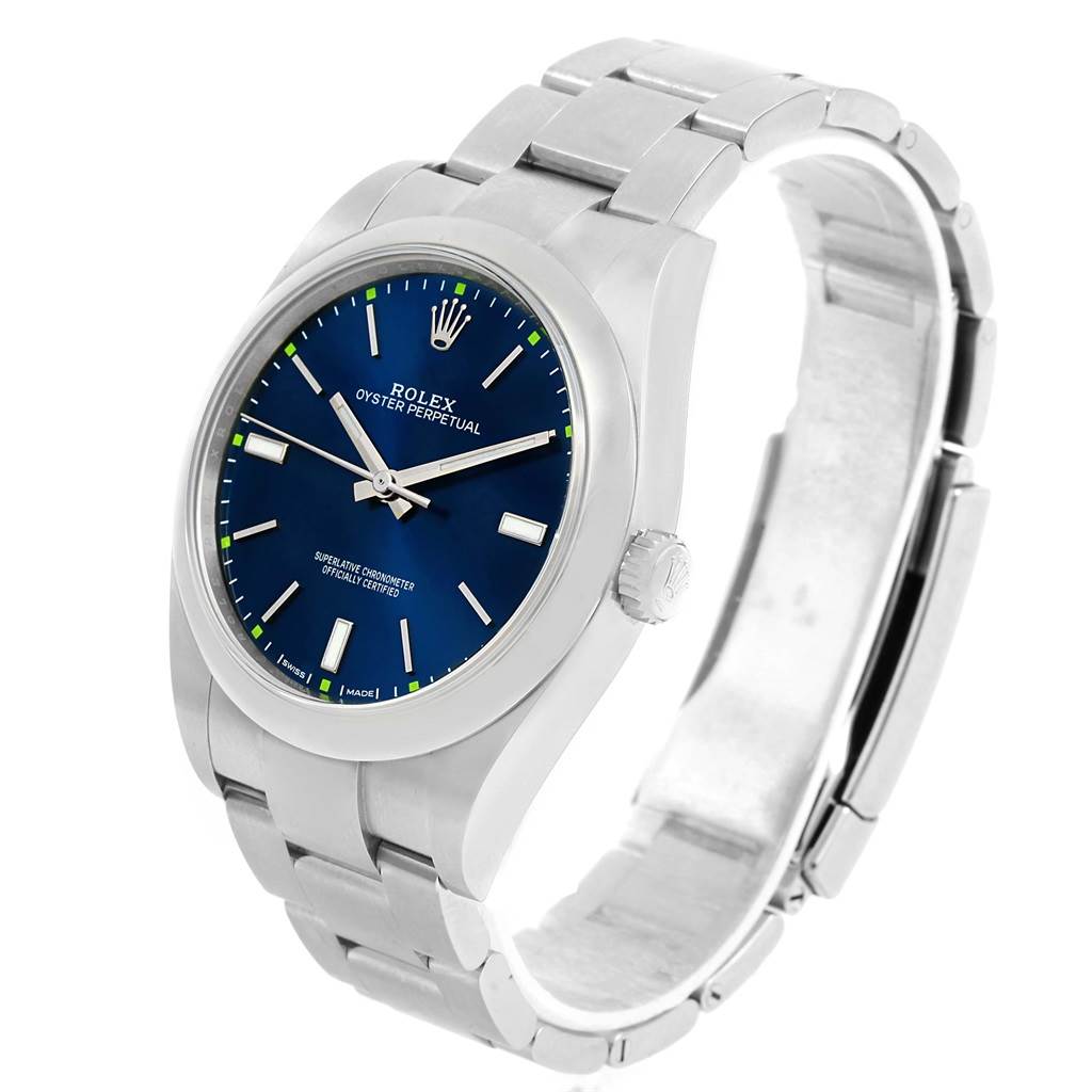 The image shows a Rolex Oyster Perpetual 114300 Men's Stainless Steel Blue Dial 114300 Men's Stainless Steel Blue Dial watch from a three-quarter angle, highlighting its blue dial and bracelet.