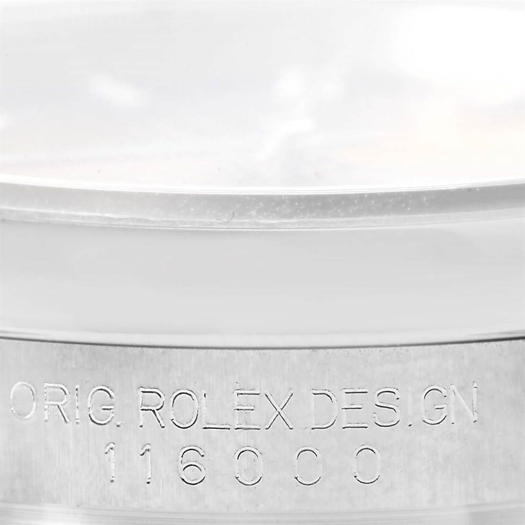 This image shows a close-up of the Rolex Oyster Perpetual 116000 Men's Stainless Steel Champagne Dial 116000 Men's Stainless Steel Champagne Dial model's case side, featuring the engraved model number "116000".