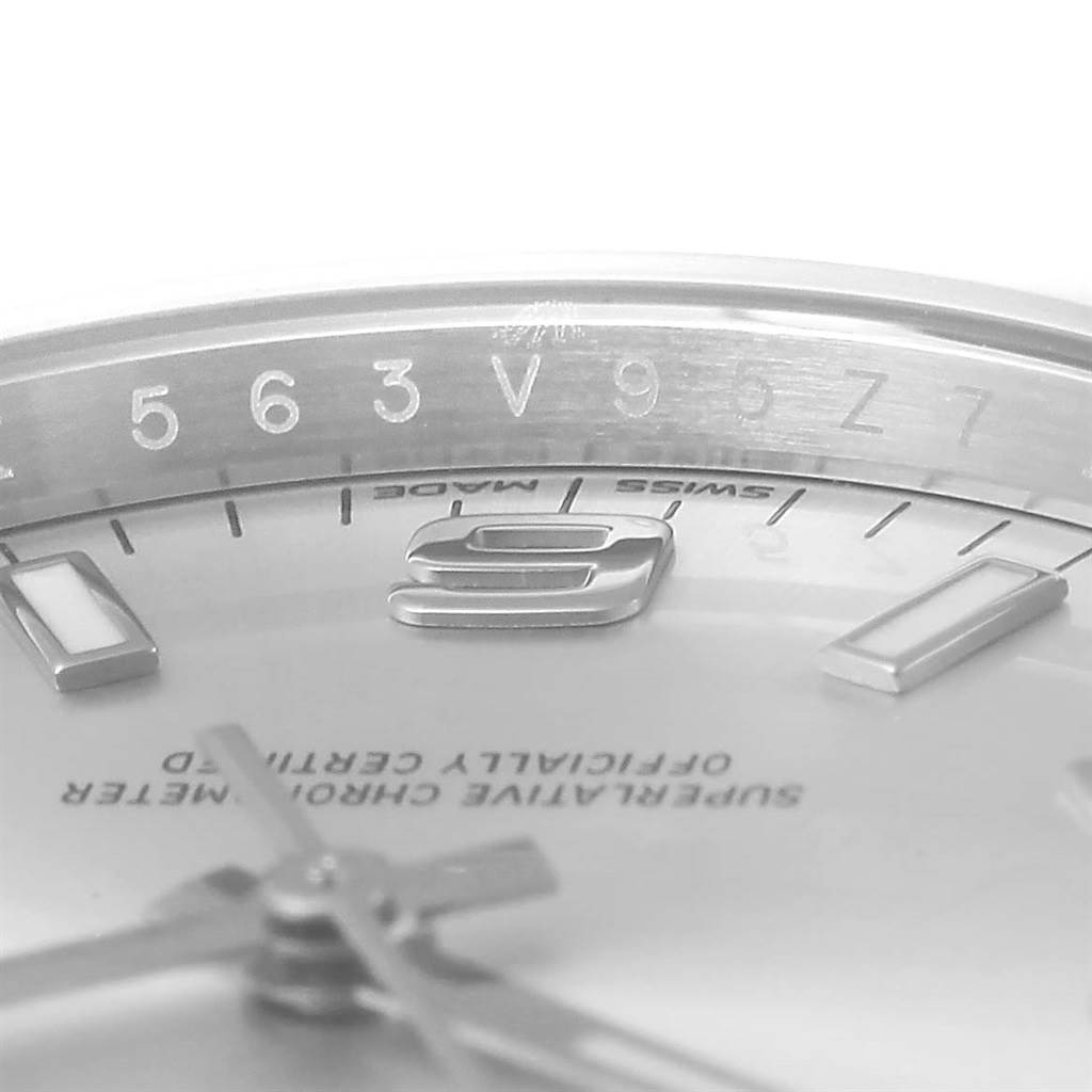 This close-up shot of the Rolex Oyster Perpetual 114200 Men's Stainless Steel Silver Dial 114200 Men's Stainless Steel Silver Dial displays the dial, hands, partial numerals and surrounding chapter ring.