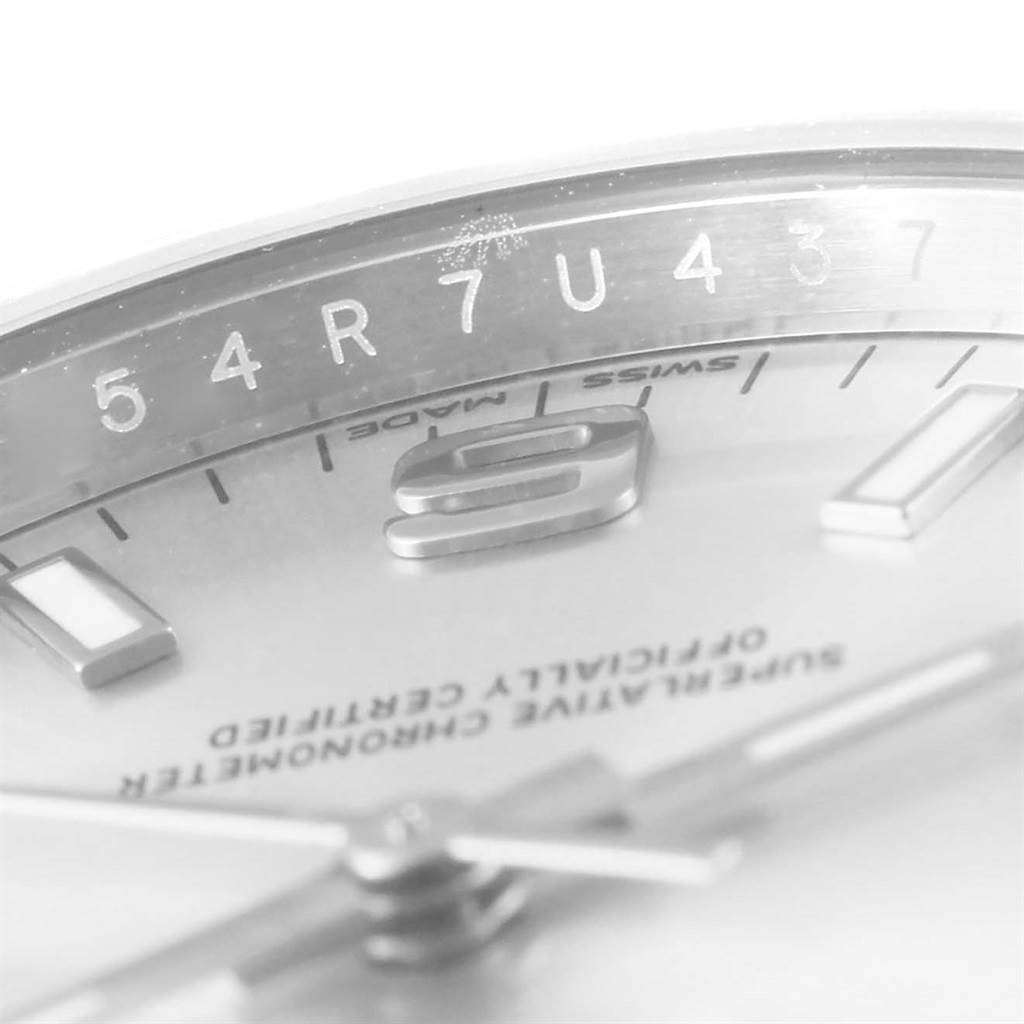 Close-up shot of the Rolex Oyster Perpetual 114200 Men's Stainless Steel Silver Dial 114200 Men's Stainless Steel Silver Dial watch showing part of the dial and serial number engraving.
