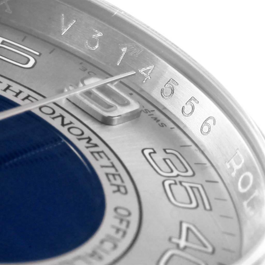 This close-up image shows the dial and bezel of a Rolex Oyster Perpetual 116000 Men's Stainless Steel Silver Dial 116000 Men's Stainless Steel Silver Dial watch, highlighting the numbers and a portion of the minute hand.