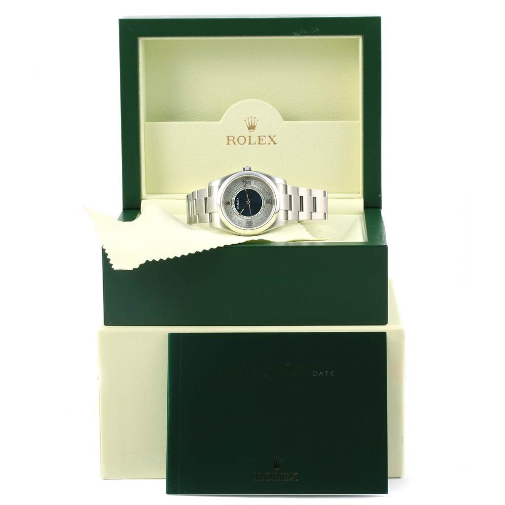 The Rolex Oyster Perpetual 116000 Men's Stainless Steel Silver Dial 116000 Men's Stainless Steel Silver Dial watch is shown in its open box, with the green Rolex booklet partially visible below.