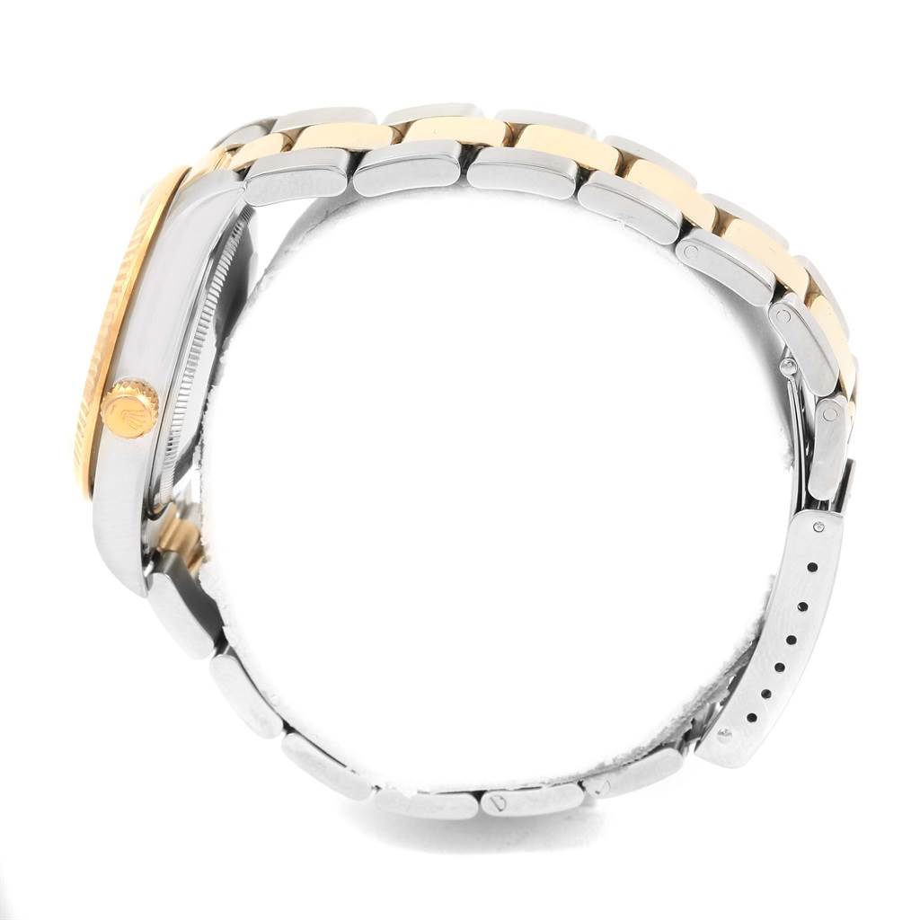 The side view of a Rolex Oyster Perpetual 14233 Men's Steel and Gold (two tone) Champagne Dial 14233 Men's Steel and Gold (two tone) Champagne Dial watch shows its crown, case, and bi-color bracelet.