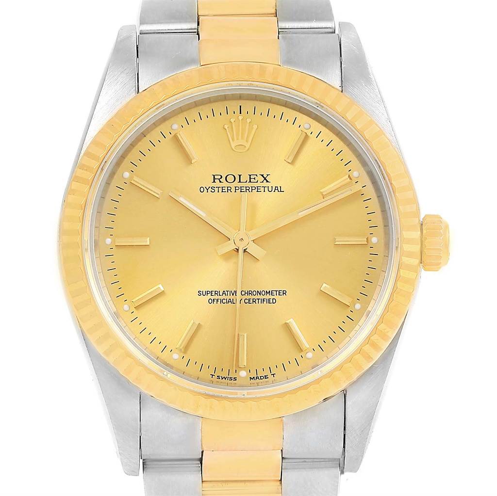 This Rolex Oyster Perpetual 14233 Men's Steel and Gold (two tone) Champagne Dial 14233 Men's Steel and Gold (two tone) Champagne Dial watch is shown from a front angle, displaying its dial, bezel, and part of its bracelet.