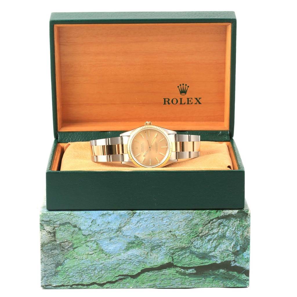 The Rolex Oyster Perpetual 14233 Men's Steel and Gold (two tone) Champagne Dial 14233 Men's Steel and Gold (two tone) Champagne Dial watch is displayed front-on in an open green box with a cushioned interior.