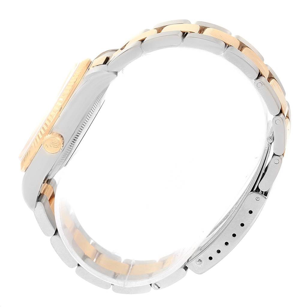 This side-angle view of the Rolex Oyster Perpetual 14233 Men's Steel and Gold (two tone) Champagne Dial 14233 Men's Steel and Gold (two tone) Champagne Dial watch showcases its two-tone bracelet and crown.