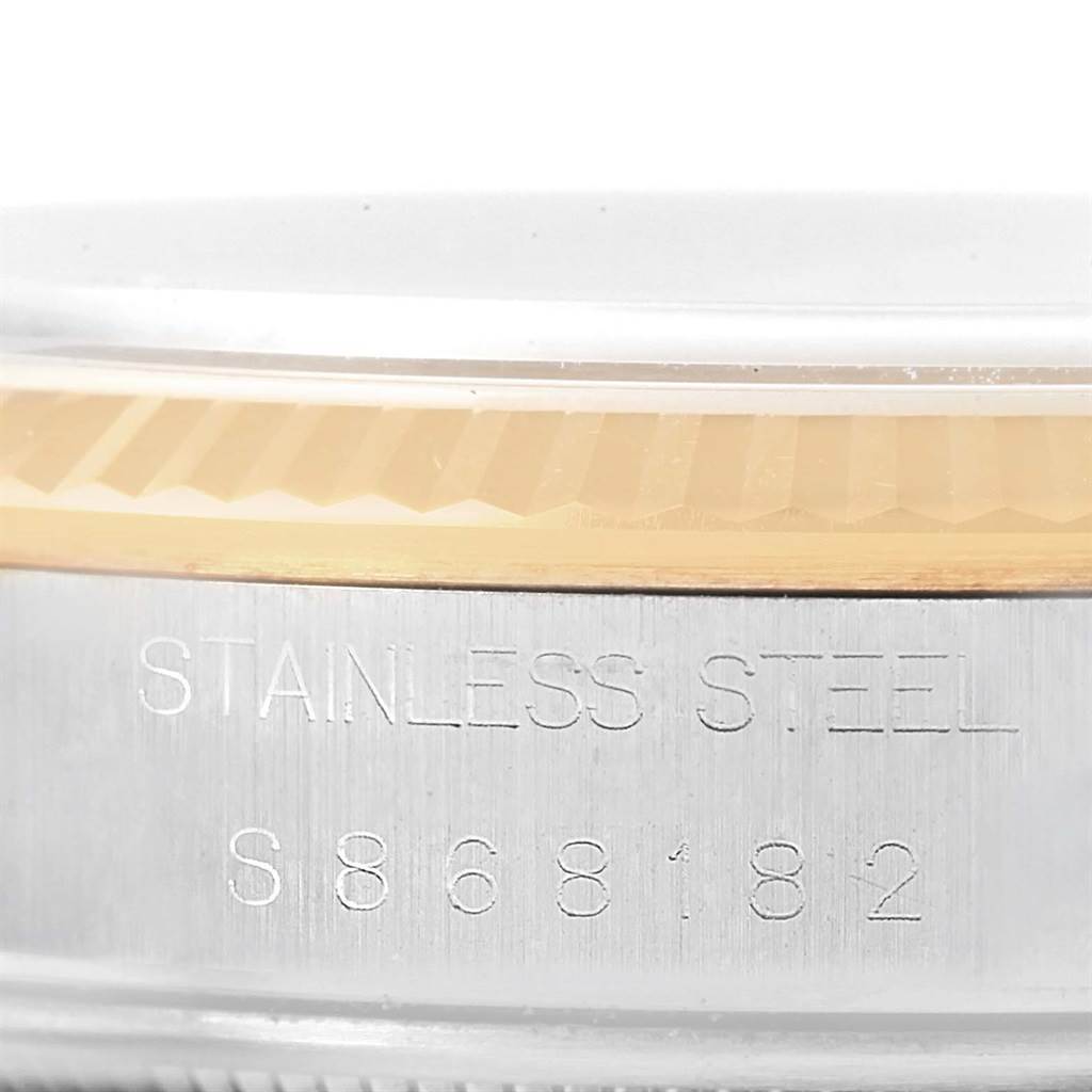 This image shows a close-up angle of the side of a Rolex Oyster Perpetual 14233 Men's Steel and Gold (two tone) Champagne Dial 14233 Men's Steel and Gold (two tone) Champagne Dial watch, focusing on the edge of the bezel and the engraved serial number.