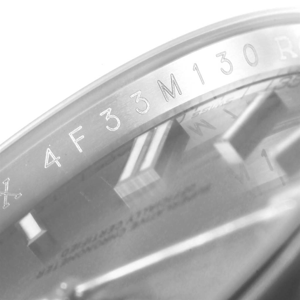 This close-up image of the Rolex Oyster Perpetual 116000 Men's Stainless Steel Grey Dial 116000 Men's Stainless Steel Grey Dial watch shows the serial number engraved on the inner bezel.