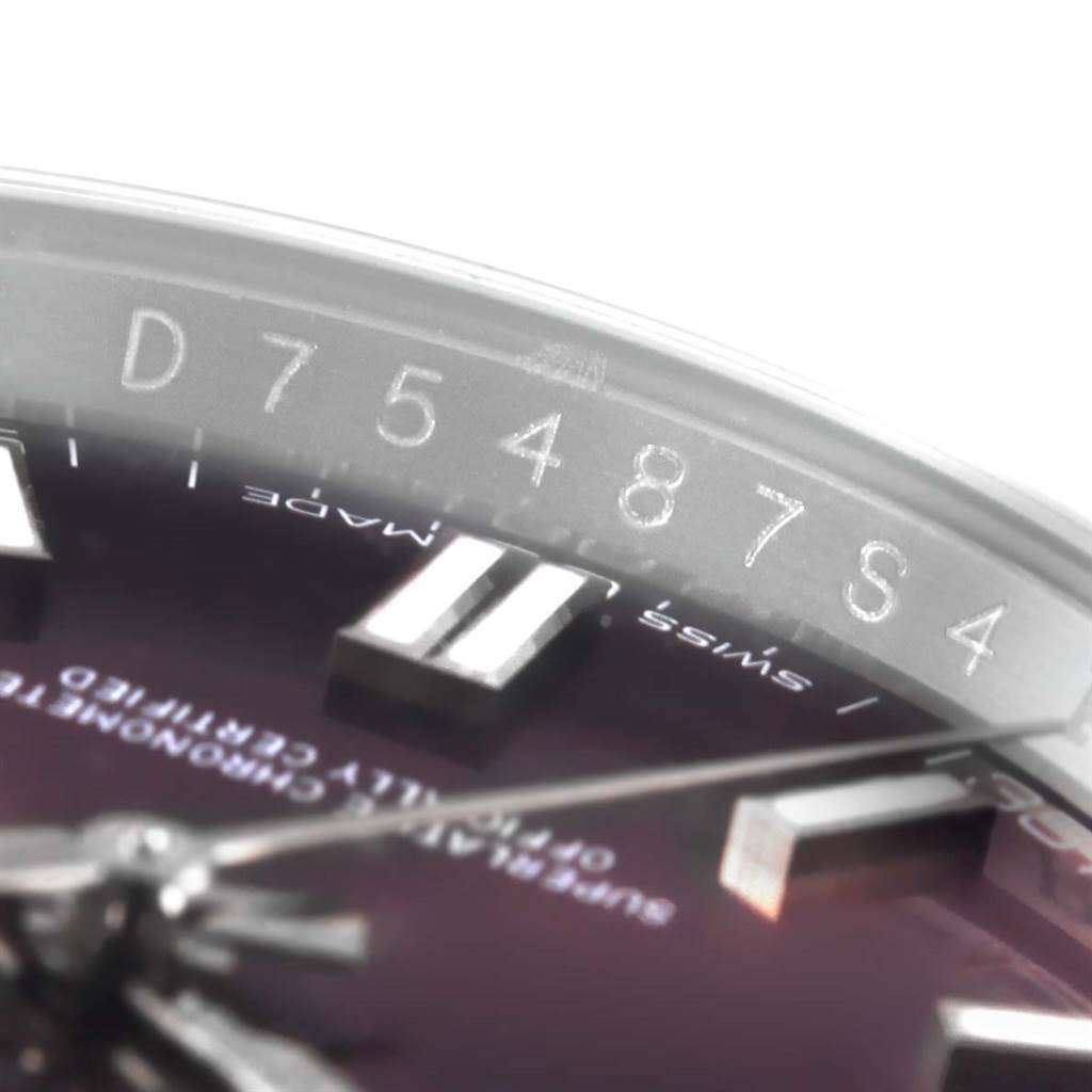 This close-up of the Rolex Oyster Perpetual 116000 Stainless Steel Burgundy Dial 116000 Stainless Steel Burgundy Dial watch shows the serial number engraved on the rehaut and part of the dial.
