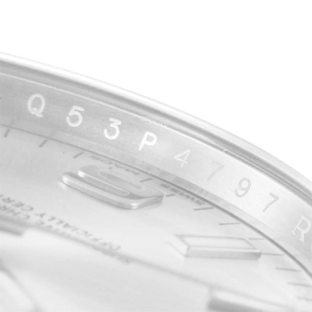 The image shows a close-up angle of the dial and edge of the bezel of the Rolex Oyster Perpetual 114200 Men's Stainless Steel Silver Dial 114200 Men's Stainless Steel Silver Dial watch.