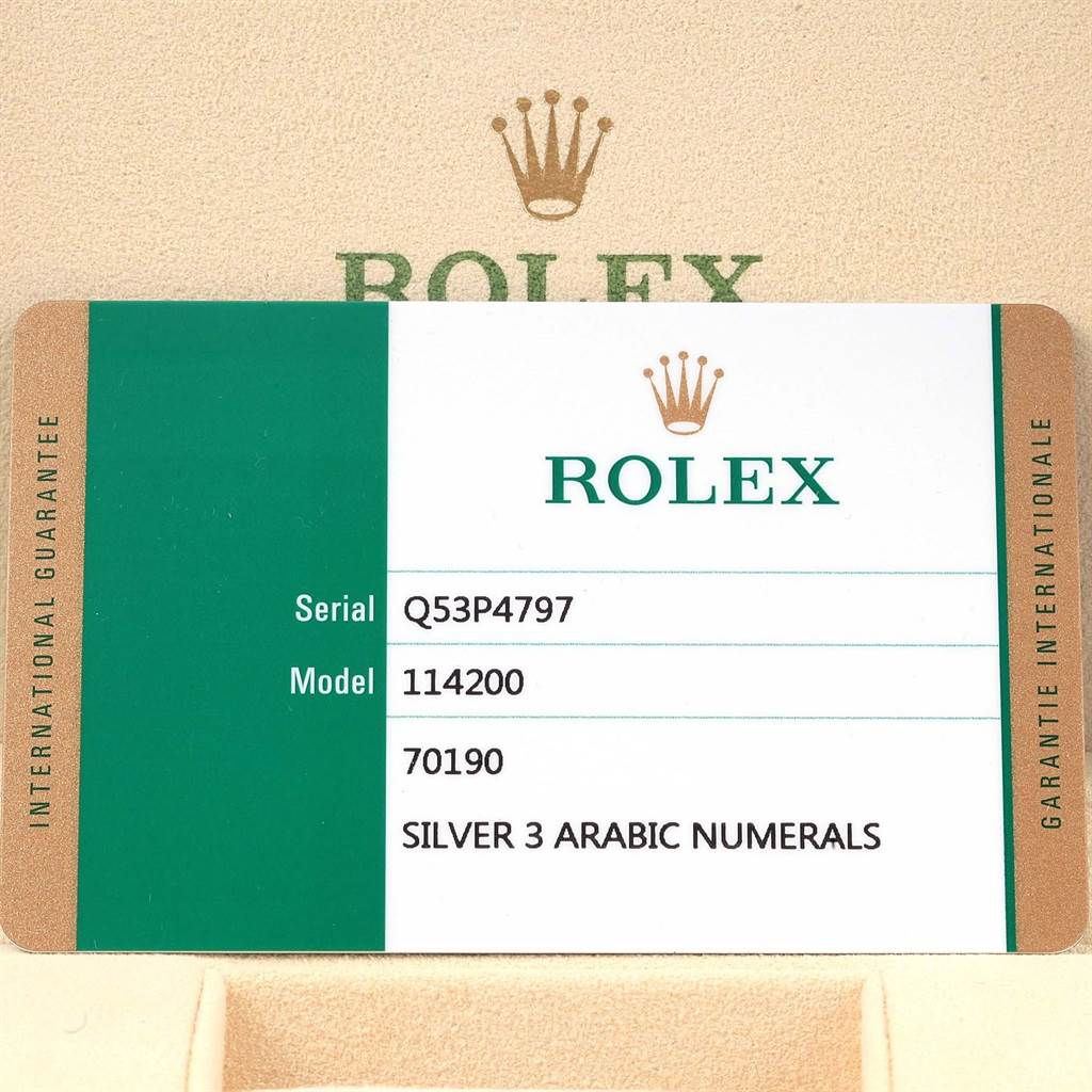 The image shows a guarantee card for a Rolex Oyster Perpetual 114200 Men's Stainless Steel Silver Dial 114200 Men's Stainless Steel Silver Dial model 114200, featuring its serial number and specific details.