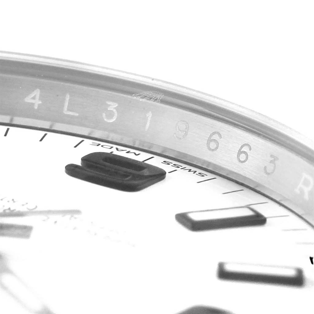 The image shows a close-up angle of the dial and serial number engraving on a Rolex Oyster Perpetual 114200 Stainless Steel White Dial 114200 Stainless Steel White Dial watch.