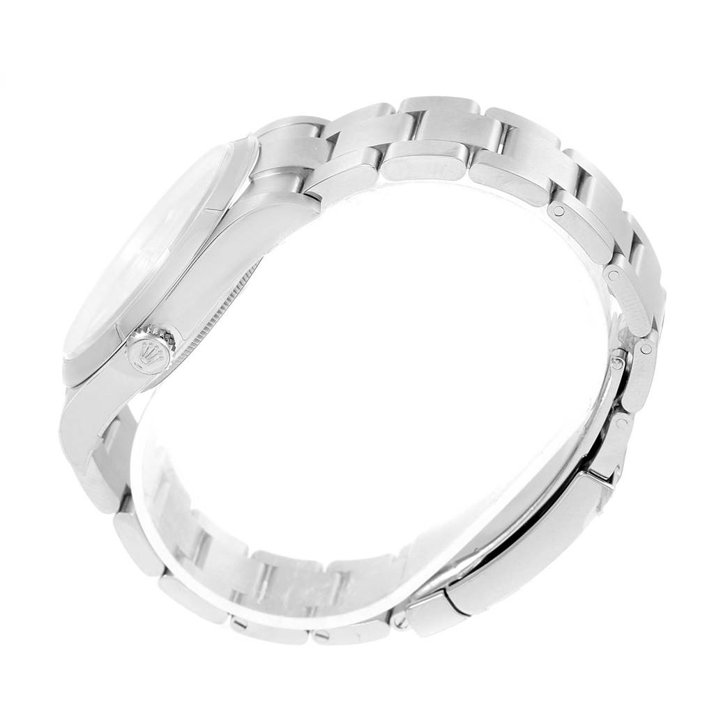 The image shows a side view of the Rolex Oyster Perpetual 114300 Stainless Steel Burgundy Dial 114300 Stainless Steel Burgundy Dial watch, highlighting its stainless steel case, crown, and bracelet.