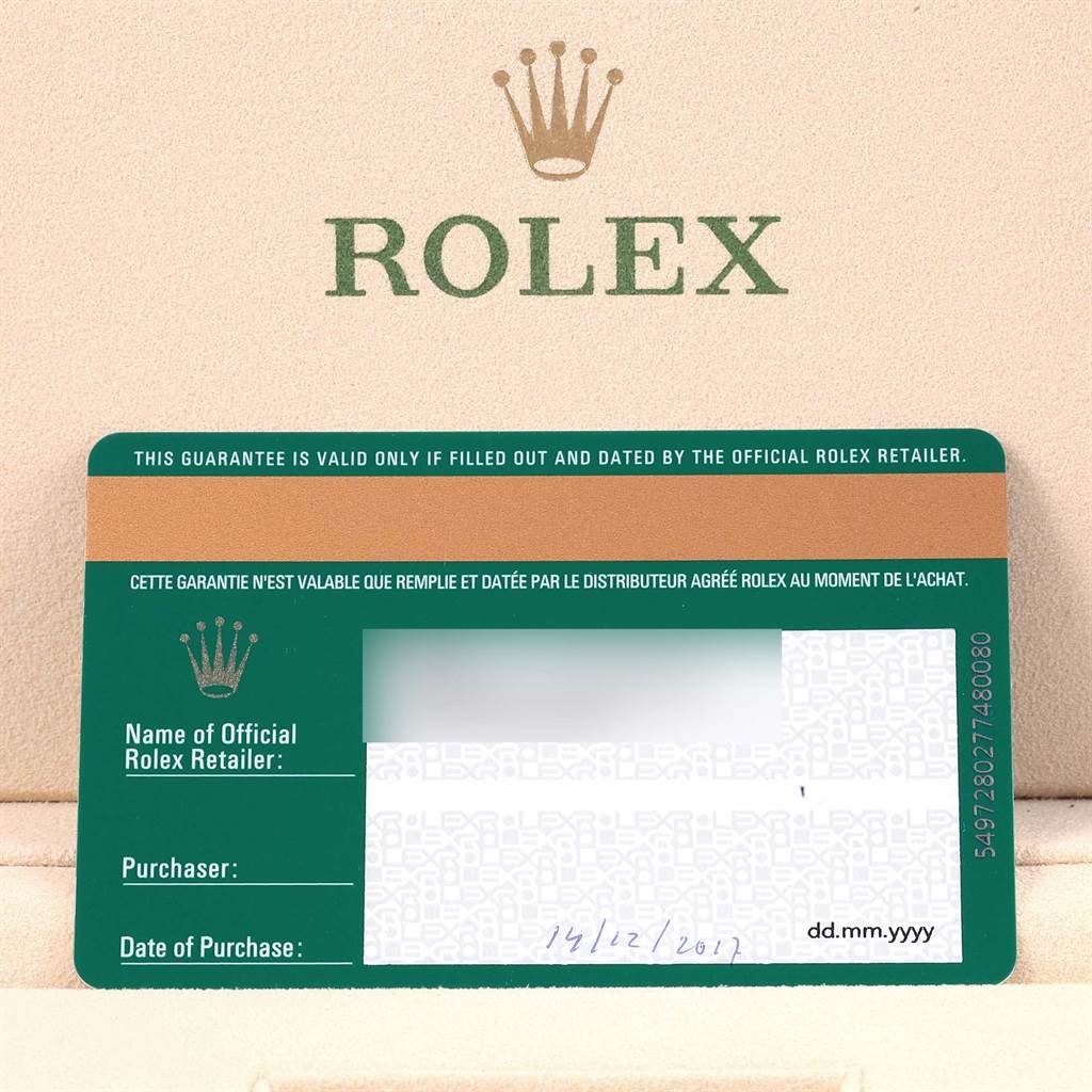The image shows the warranty card for a Rolex Oyster Perpetual 114300 Stainless Steel Burgundy Dial 114300 Stainless Steel Burgundy Dial watch against a background with the Rolex logo.