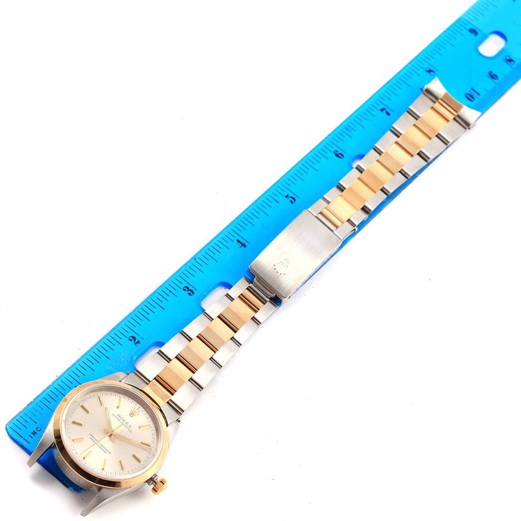 The image displays a Rolex Oyster Perpetual 14203 Steel and Gold (two tone) Silver Dial 14203 Steel and Gold (two tone) Silver Dial watch with a gold and silver bracelet, alongside a blue ruler for scale.