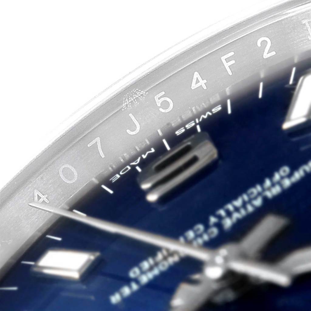 This close-up image focuses on the dial and part of the bezel of a Rolex Oyster Perpetual 114200 Men's Stainless Steel Blue Dial 114200 Men's Stainless Steel Blue Dial watch.