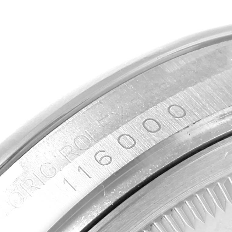 This close-up image shows the serial number and part of the bezel edge of the Rolex Oyster Perpetual 116000 Men's Stainless Steel Silver Dial 116000 Men's Stainless Steel Silver Dial model.